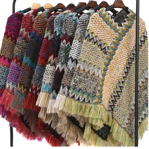 Close-up of colorful ethnic style knit ponchos with zigzag patterns and fringe details.