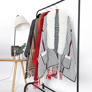 Elegante poncho de punto con borlas gruesas y cuello de piel sintética de pata de gallo