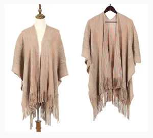 Elegant warm knitted poncho shawl with fringe detail shown on mannequin and hanger