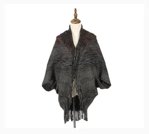 Elegant warm warp-knitted poncho shawl with fringe detail displayed on mannequin
