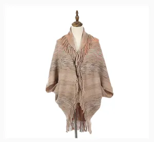 Detailed mannequin display of fall knit poncho shawl with fringe in earth tones.