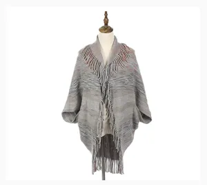 Detailed macro view of gray marl knitted poncho shawl with elegant fringe collar