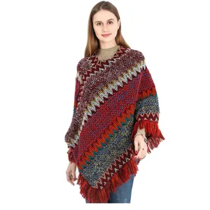 Colorful ethnic knitted poncho with fringe detail worn by model for autumn winter