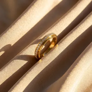 Macro di un anello rotante in acciaio al titanio dorato con file di cristalli scintillanti.