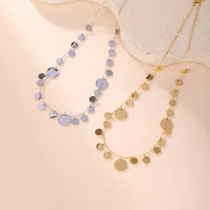 Detail view of gold and silver necklaces with multiple shiny dangling metal disc charms.