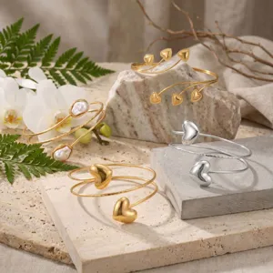 Close-up of elegant gold and silver geometric heart arm cuffs on natural stone slabs