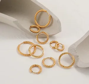 Detailed view showing multiple sizes of gold titanium steel textured hoop earrings