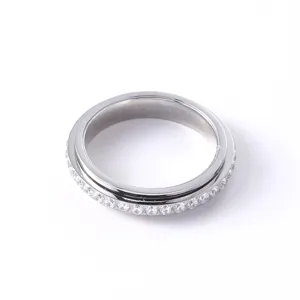 Inquadratura macro dettagliata di un anello rotante in acciaio titanio con diamanti