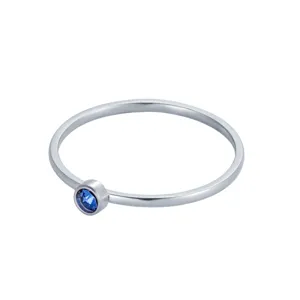 Vue rapprochée d'une bague minimaliste en argent avec une pierre précieuse bleue