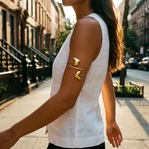 Close-up detail showing the metallic texture of a gold heart-shaped geometric arm cuff