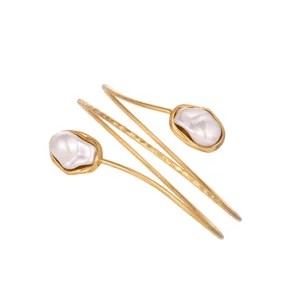 Close-up detail of a minimalist golden geometric arm cuff featuring a unique baroque pearl