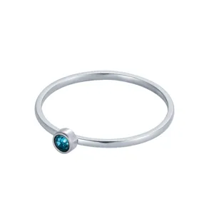 Vue rapprochée d'une bague fine en argent ornée d'une pierre de naissance bleue