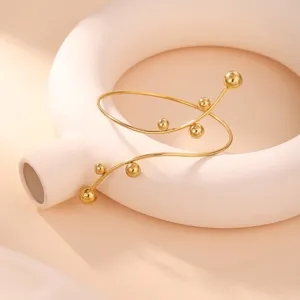 Vista dettagliata di un elegante bracciale geometrico dorato con piccole sfere