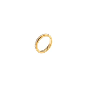 Elegante anello rotante in acciaio al titanio dorato con zirconi su sfondo bianco puro
