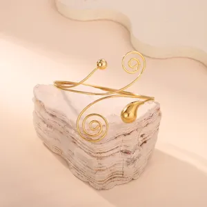 Dettaglio di un elegante bracciale da braccio geometrico dorato con design a spirale