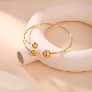 Primo piano di un bracciale da braccio geometrico dorato con perline lucide