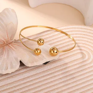 Elegante bracciale geometrico dorato con tre sfere lucide mostrato nei dettagli