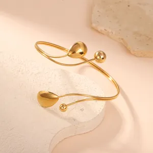 Elegante bracciale geometrico dorato con ciondoli a goccia su una base in pietra