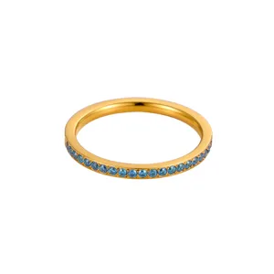 Detalle de un anillo eternity dorado con pequeñas circonitas azules redondas alrededor