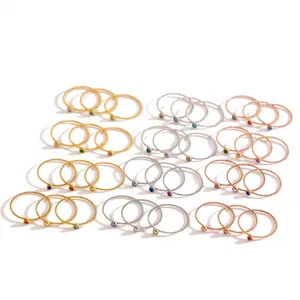 Vista dettagliata di anelli a treccia con pietre portafortuna in oro, argento e oro rosa