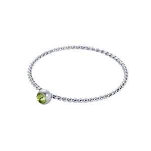 Dettaglio dell'anello in argento ritorto con una pietra preziosa peridoto verde rotonda