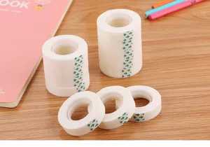 Detail showing multiple rolls of semi-transparent invisible tape on a wooden desk