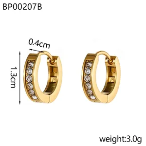 Détail de boucles d'oreilles créoles dorées de 1,3 cm avec zircone claire incrustée
