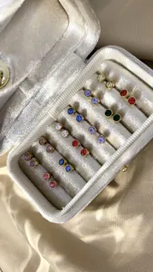 Detailweergave van kleurrijke ronde kristallen oorknopjes in een luxe fluwelen doosje