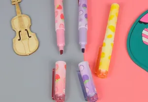 Macrodetail van mini fruit-highlighters met vrolijke aardbei- en mangopatronen nu