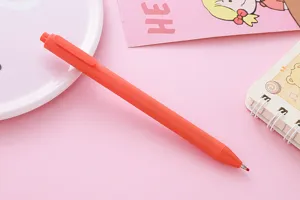 Detail view of a vibrant orange retractable gel pen on a cute pink stationery background.
