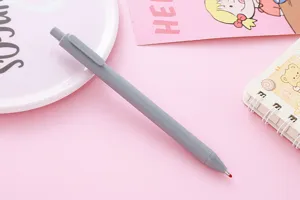 Macro view of a grey Morandi retractable gel pen on a cute pink stationery background