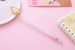 Primer plano de un bolígrafo de gel de calabaza de cristal rosa en fondo de papelería.