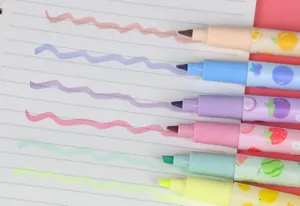 Detailweergave van gekleurde markeerstiften met fruitpatroon en inktstrepen op papier