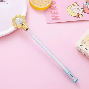 Cute creative gel pen featuring a gold flower top and crystal bead on a pastel pink background