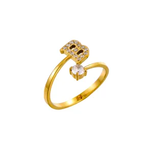 Anillo abierto dorado con amuleto letra B y detalle de circonita cúbica.