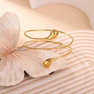 Macro vista di un bracciale a spirale dorato con eleganti estremità a goccia in oro