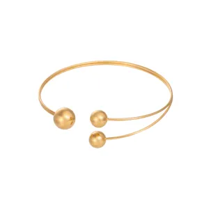 Vista dettagliata dell'elegante bracciale da braccio dorato con sfere lucide su sfondo bianco