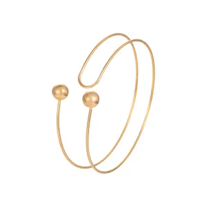 Vista dettagliata di un elegante bracciale da braccio dorato a doppio filo con sfere