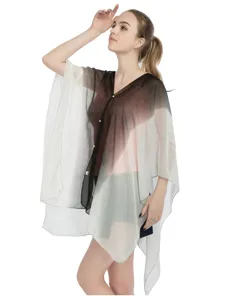 Detalle de un elegante poncho de gasa degradada con botones de perlas