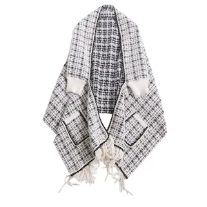 Capa de punto con estampado de pata de gallo en blanco y negro con bolsillos y flecos.