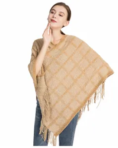 Detaillierte Makroansicht eines beigen Chenille-Strickponchos mit Karomuster und Fransen
