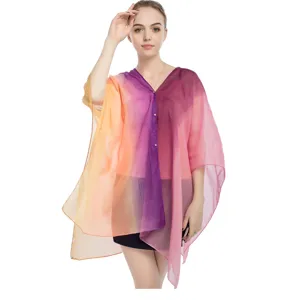 Modelo luciendo un poncho de gasa degradada con elegantes detalles de botones de perlas