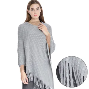 Poncho en maille grise élégant pour femme avec fil métallisé et détails à franges.