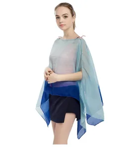 Modelo con un poncho de gasa en degradado azul con elegantes detalles de perlas