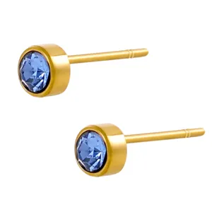 Close-up van elegante goudkleurige oorknopjes met sprankelende blauwe kristallen