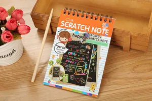 Primo piano di un colorato taccuino per scratch art per bambini con strumento in legno incluso