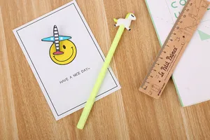 Détail macro d'un mignon bouchon licorne blanche sur un stylo gel vert lime mignon
