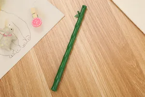 Primer plano de un creativo bolígrafo de gel con forma de bambú verde en madera