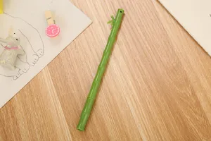 Detalle de un bolígrafo de gel creativo con forma de bambú verde sobre un escritorio de madera.