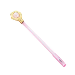 Cute pink gel pen with golden flower top and crystal bead detail on white background